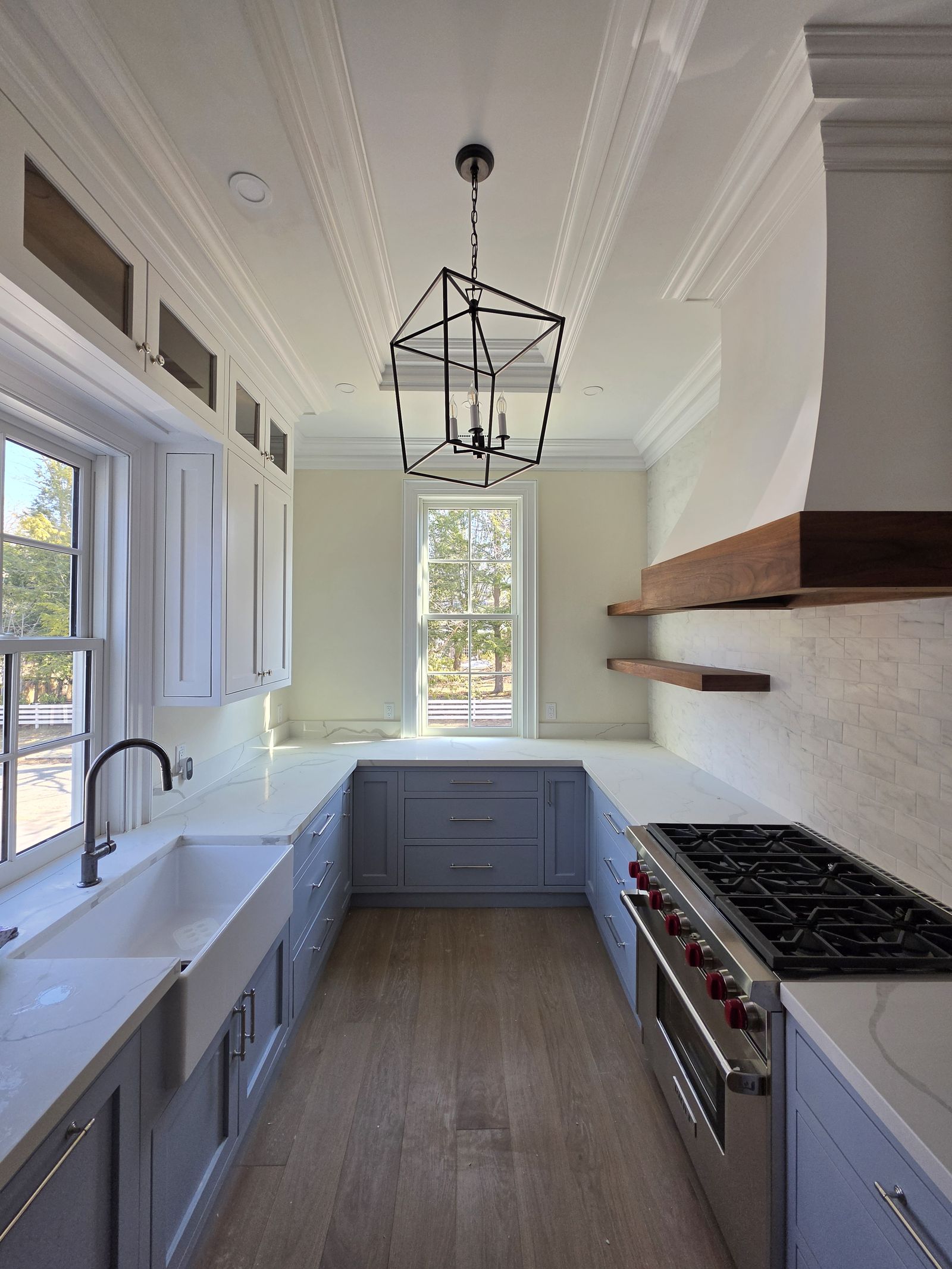 Blue inset kitchen with farmhouse sink, plaster hood and walnut shelves