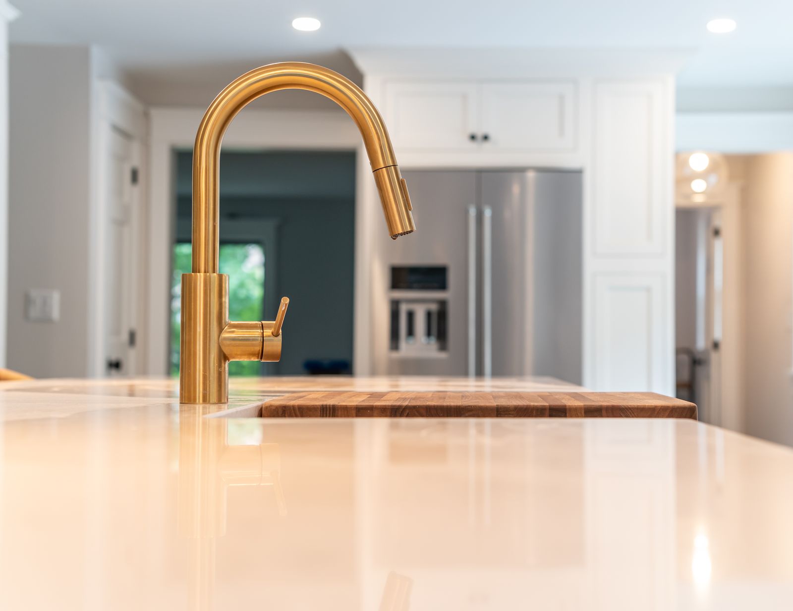 Brass faucet on quartz island with butcher block insert