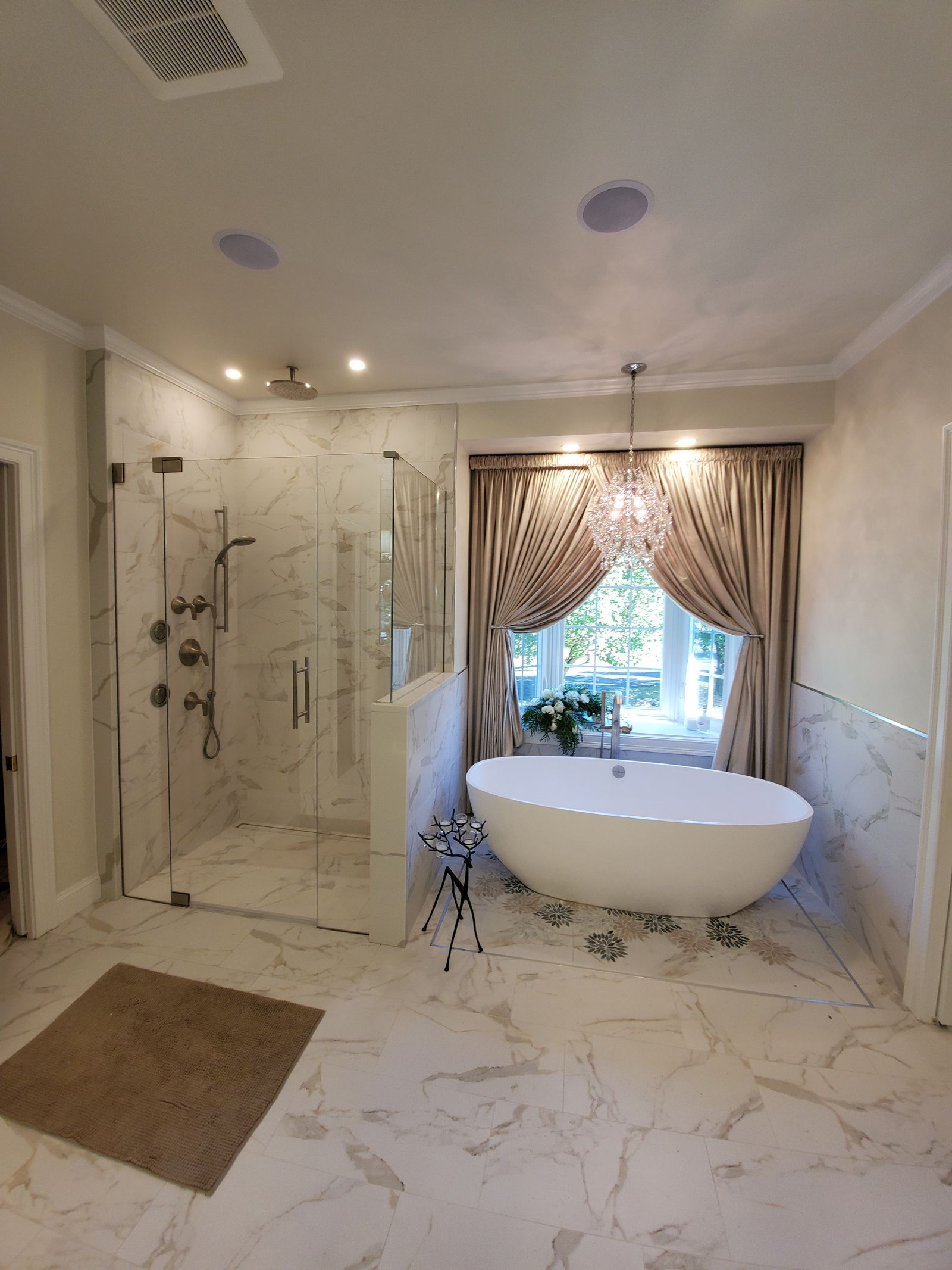 Marble primary bath with glass shower and freestanding tub