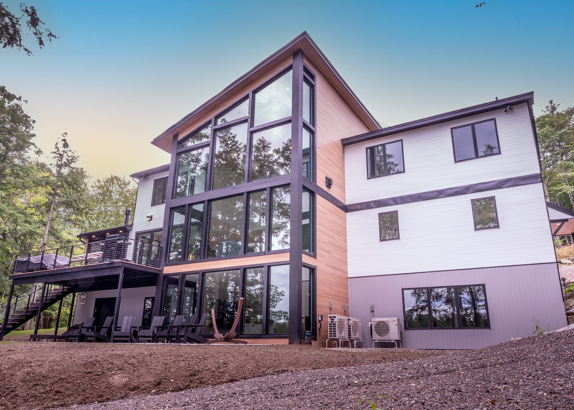 Modern custom home with a two-story glass gable and cedar siding