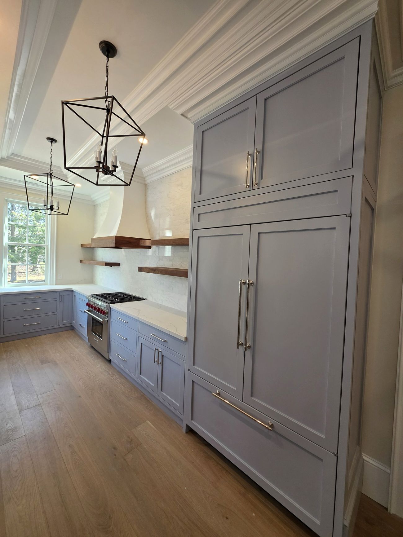 Paneled built-in refrigerator with inset cabinetry and crown molding