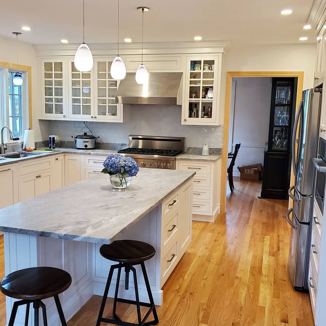 White kitchen with glass-front uppers and marble island