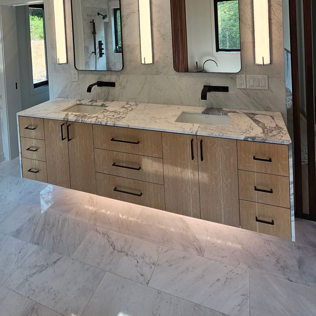 Floating white oak double vanity with marble top and under-lighting